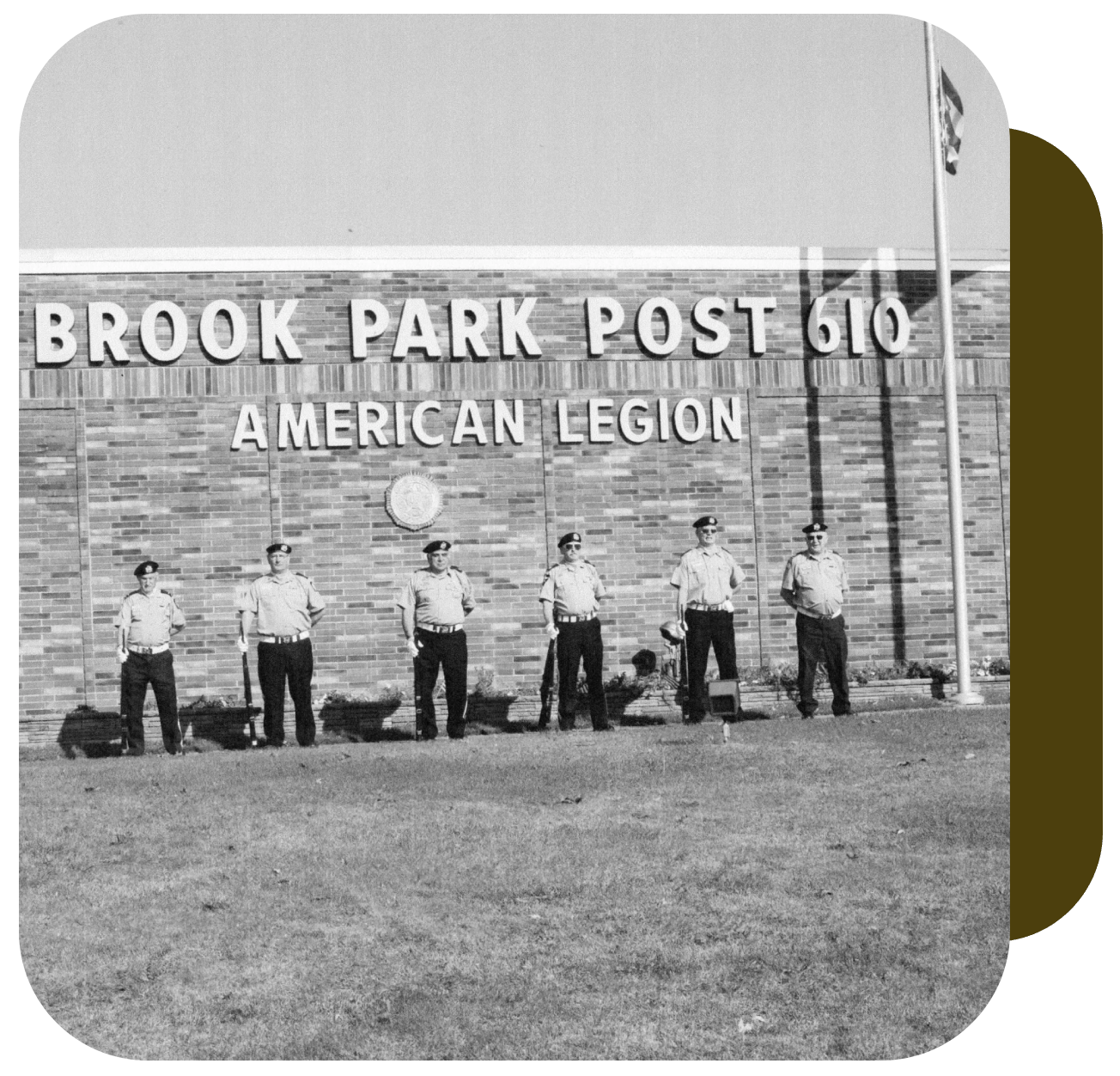 A group of men standing in front of a brick building.